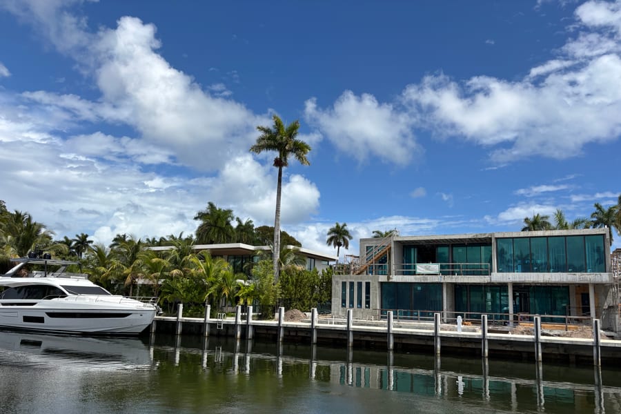 Motor yacht docked behind a modern waterfront home on a Fort Lauderdale canal