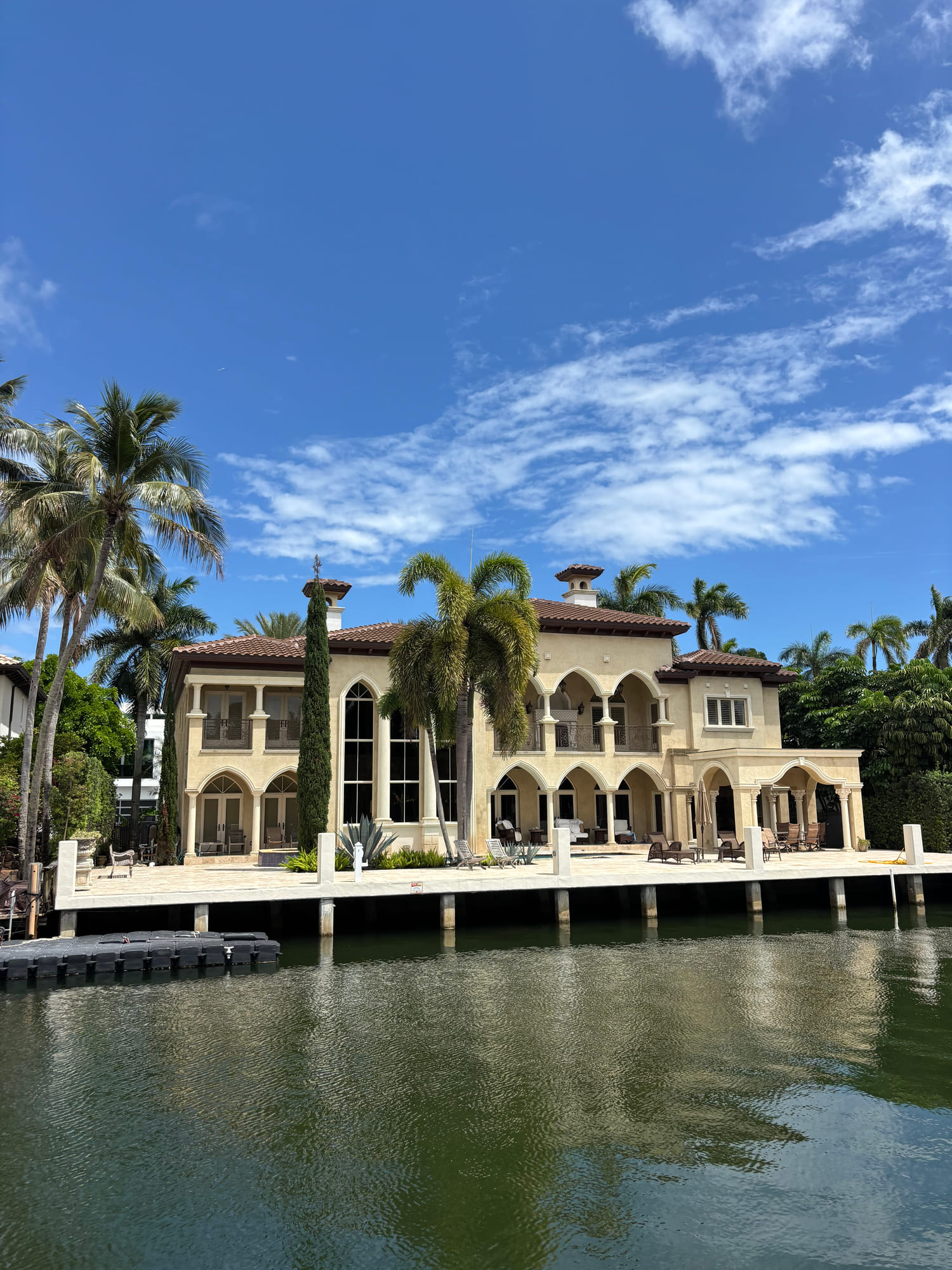Large waterfront estate with palms on a South Florida canal