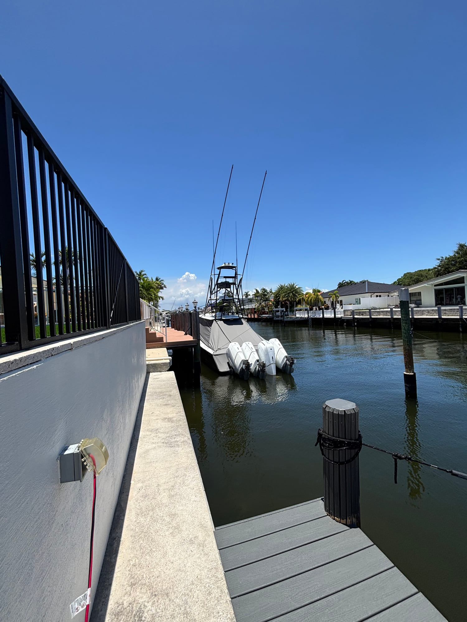 View along a private dock toward open water on a South Florida canal