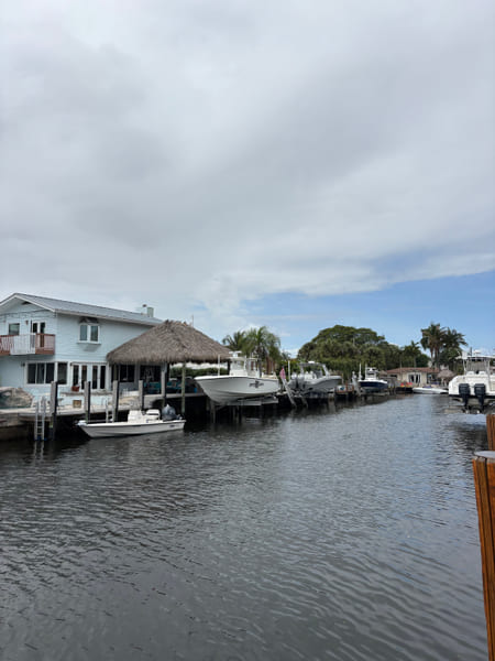 Boats moored along a residential canal in East Pompano Beach